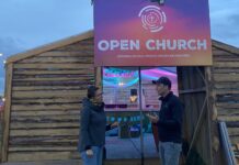 Zwischen Bass und Lagerfeuer Mitten im Festival: Pfarrerin Meike Müller-Stach spricht vor der „Open Church“ mit einem Festivalbesucher. Die kleine Holzkirche ist Anlaufstelle für Seelsorge, Begegnung und kurze Auszeiten. Foto: Privat